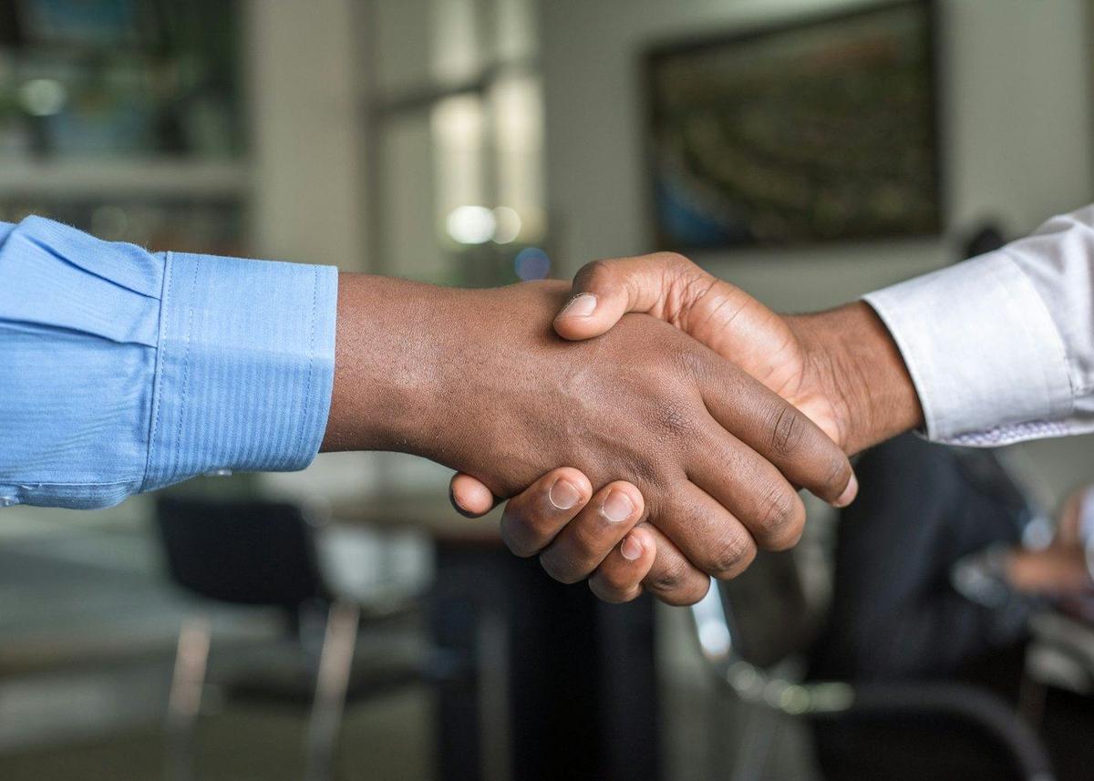Two people shaking hands to close a private lending arrangement