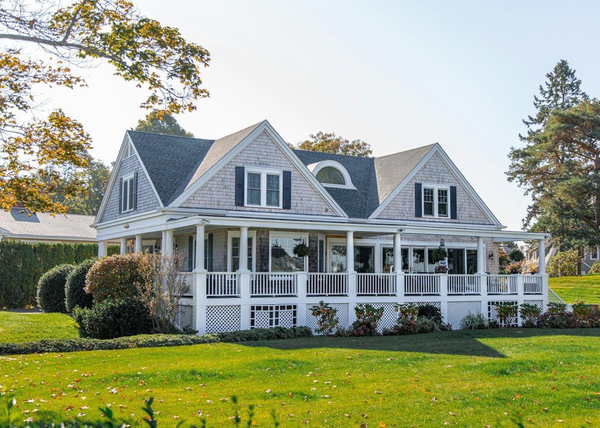 A detached family home with a wide front porch and lawn